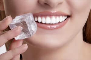 Woman holding an ice cube to here mouth