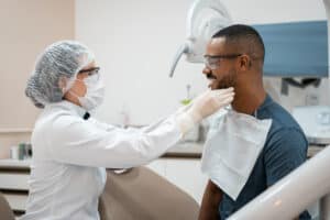 Gumy Smile: dentist checking man's mouth