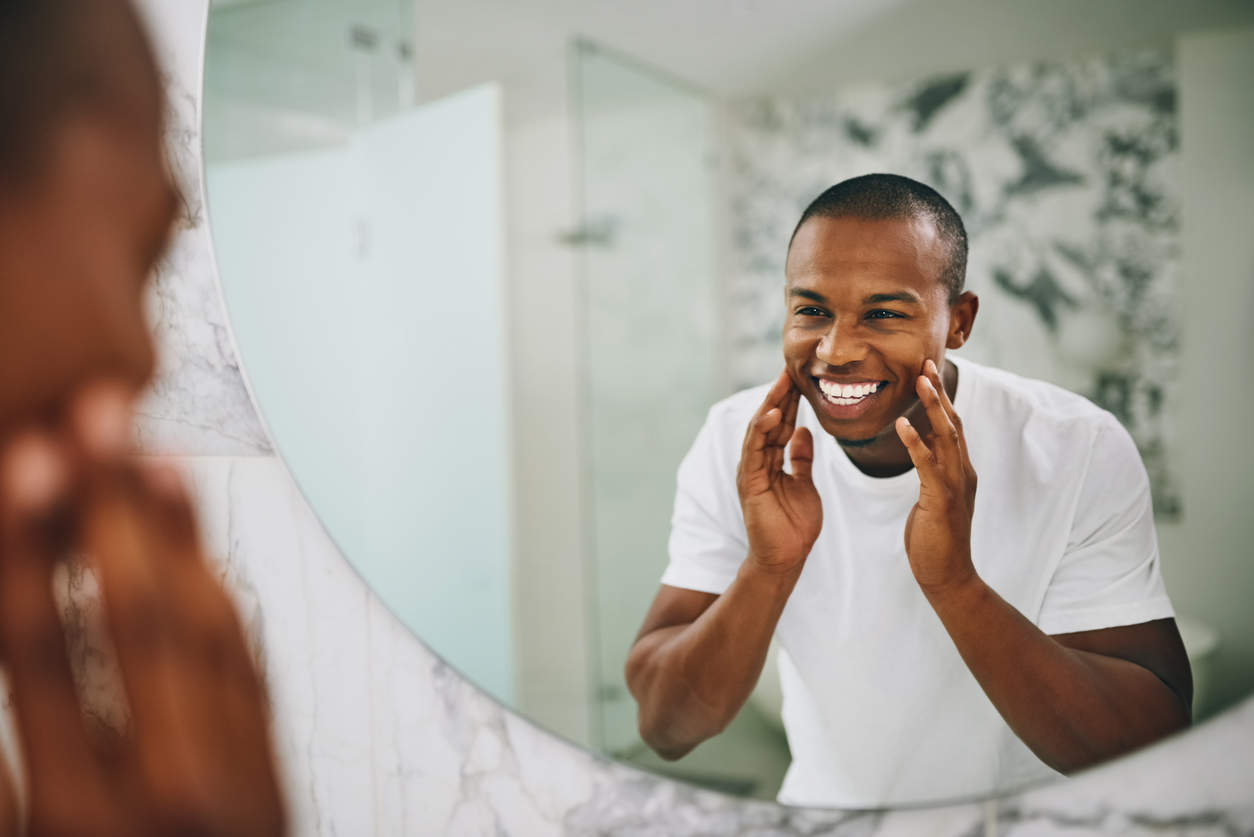 Man practicing smiling in the mirror