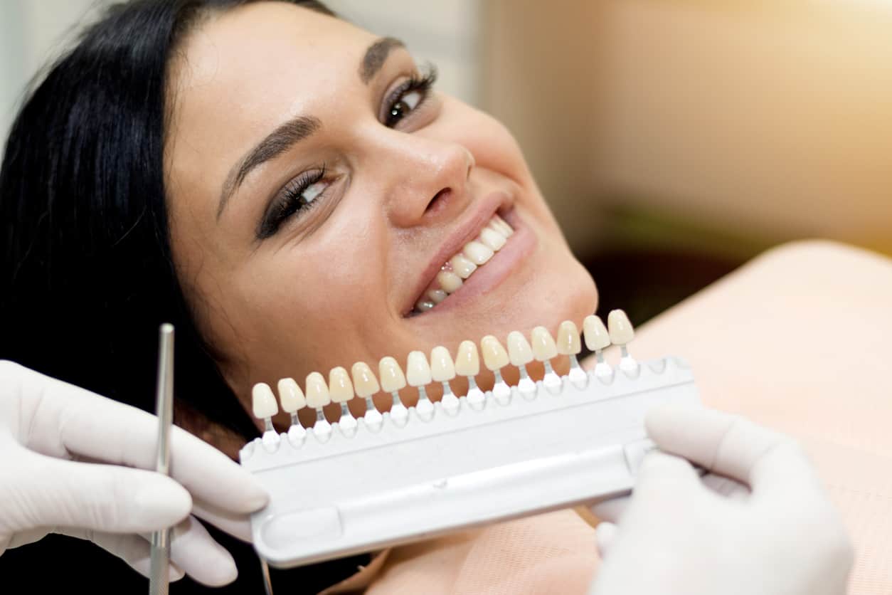 Woman getting matched for veneers in dental office