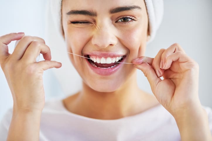 A woman flossing an winking