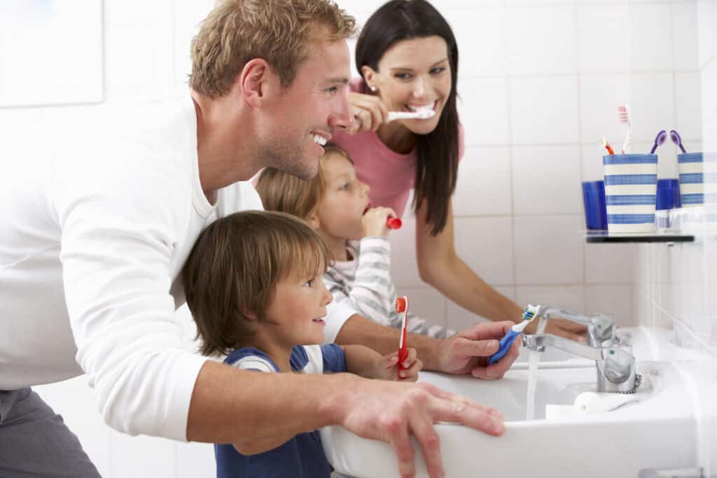 A family in the bathroom brushing their teeth